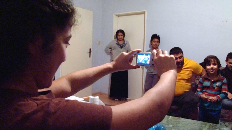 Frau macht Foto von anderen Menschen mit Smartphone