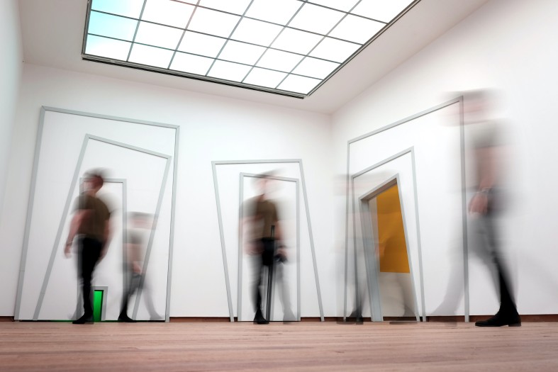 Ausstellungsraum mit verschiedenen geometrischen Formen und Linien, mehrere Besucher sind darauf verschwommen zu sehen