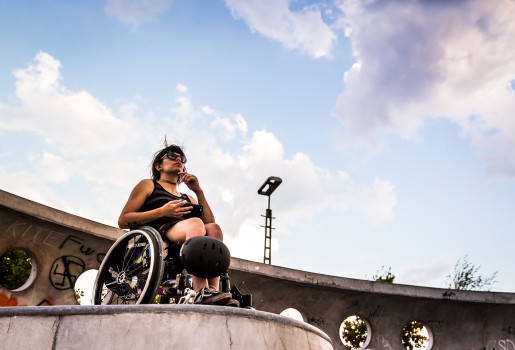 Frau im Skatepark mit Helm und Rollstuhl